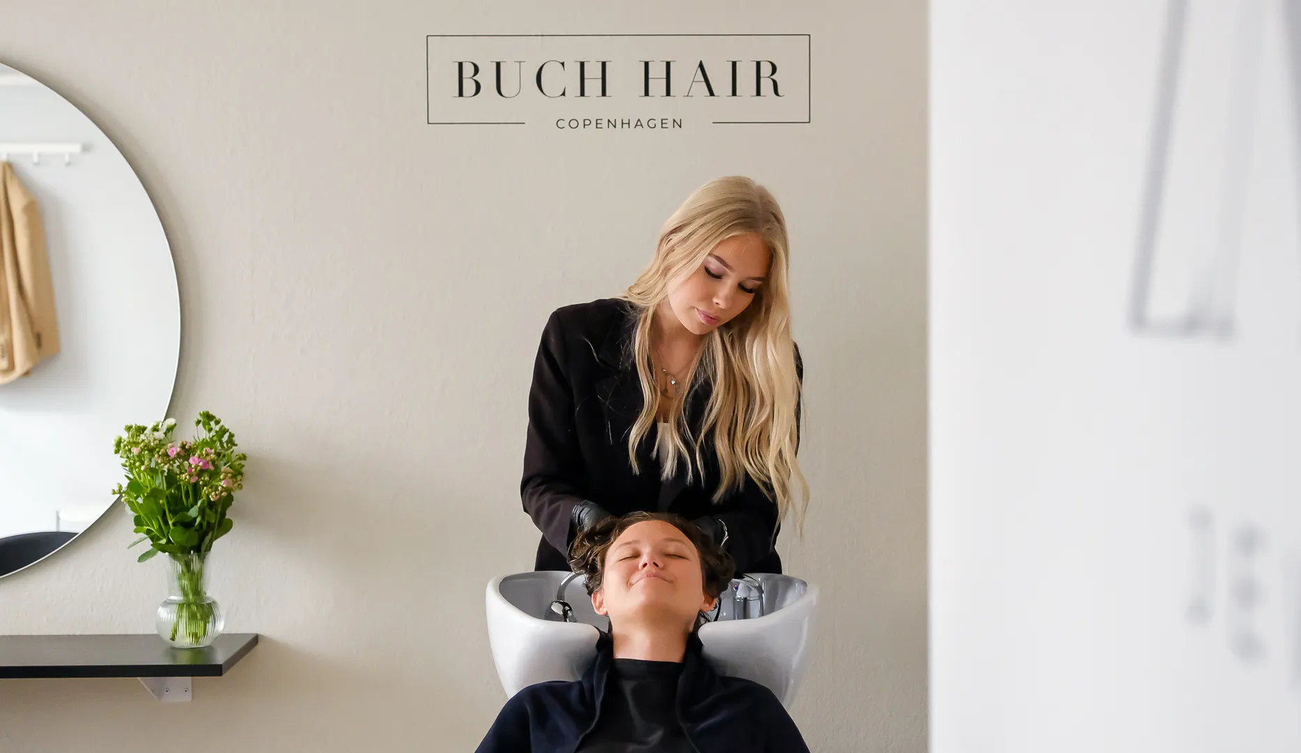 Buch Hair Studio salonen — hovedbundsvask under Buch Hair Studio Copenhagen-logoet